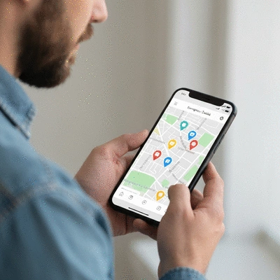 Person using a smartphone to search for an emergency dentist near them, with a map and dental icons on screen. No text, no words, no typography, no labels, clean image.